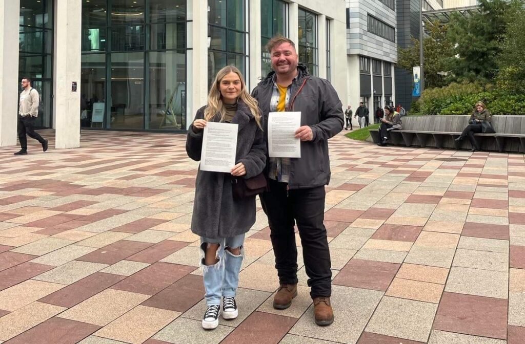 Lucy Challoner (left) and David Grimm (right) who are leading the @swstudentsunite campaign hold the jointly signed letter on 28th October 2022.
